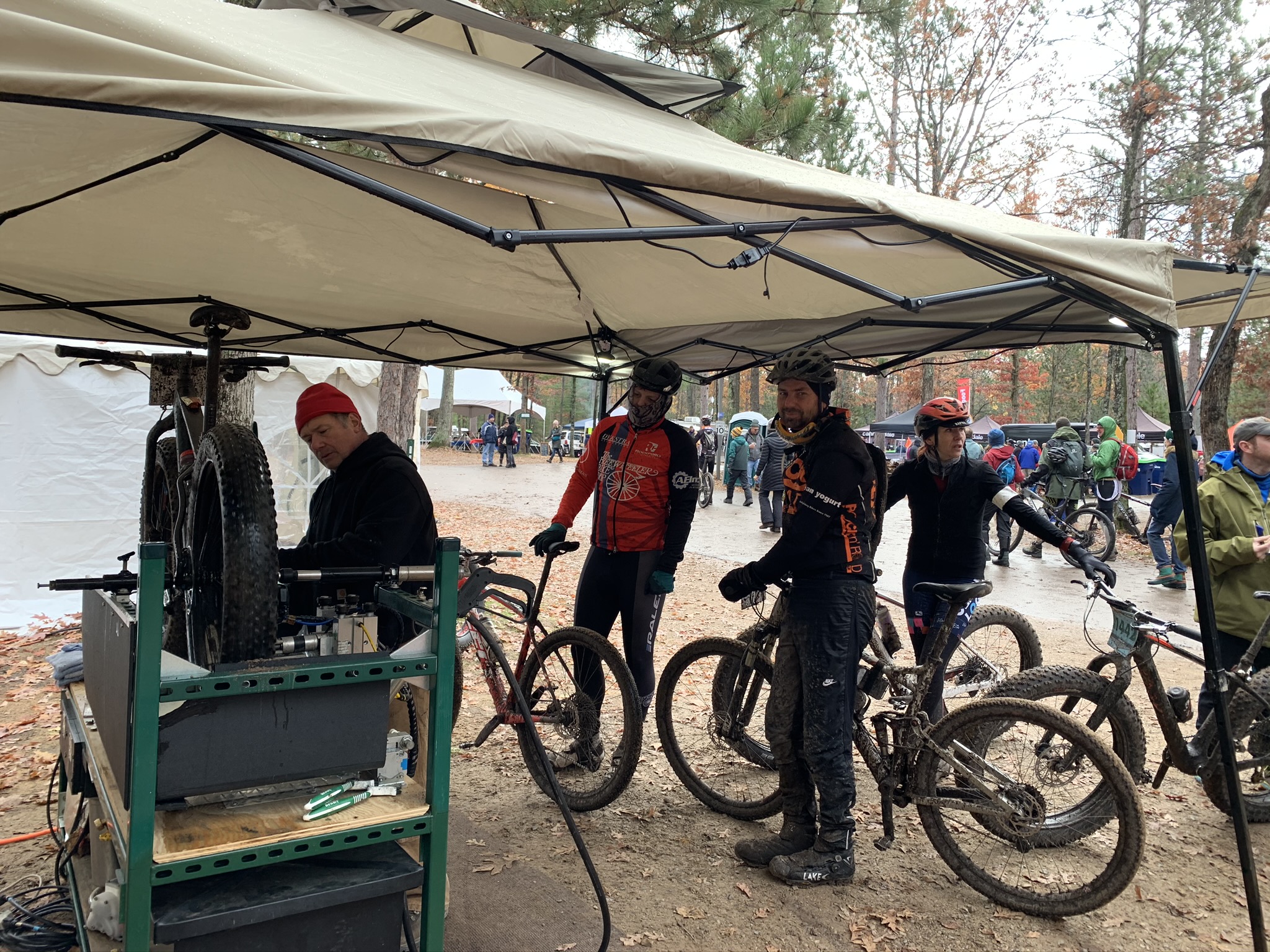 Four bicyclists wait in line to have their bicycles cleaned and lubricated by the VonBuckinator™